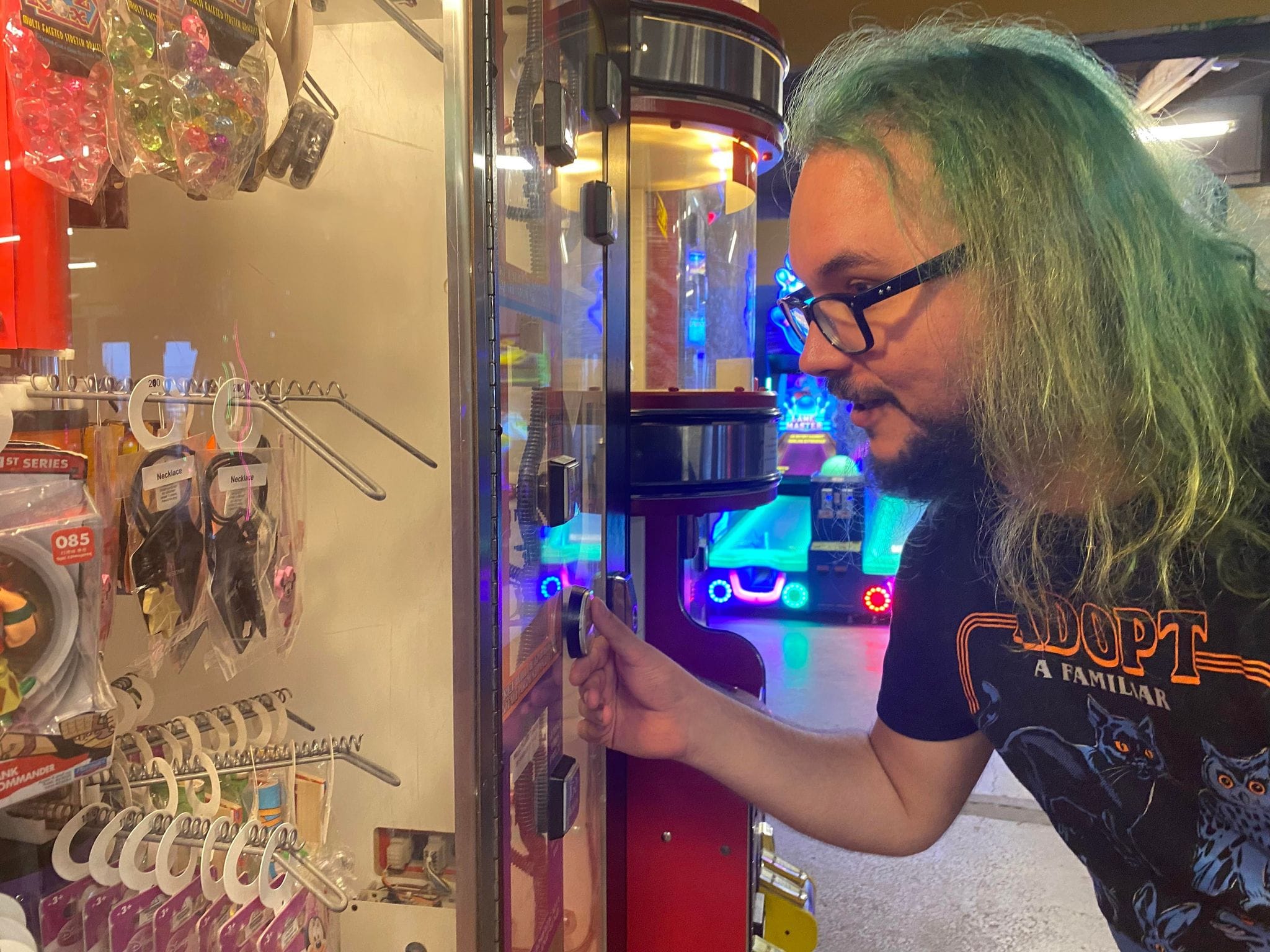 A man with green hair examines available prizes, Photo 1